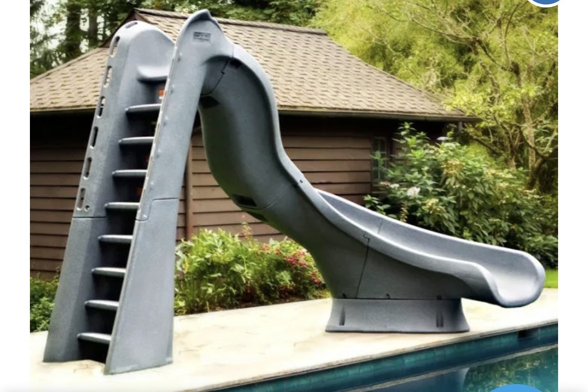 Gray curved pool slide beside a swimming pool